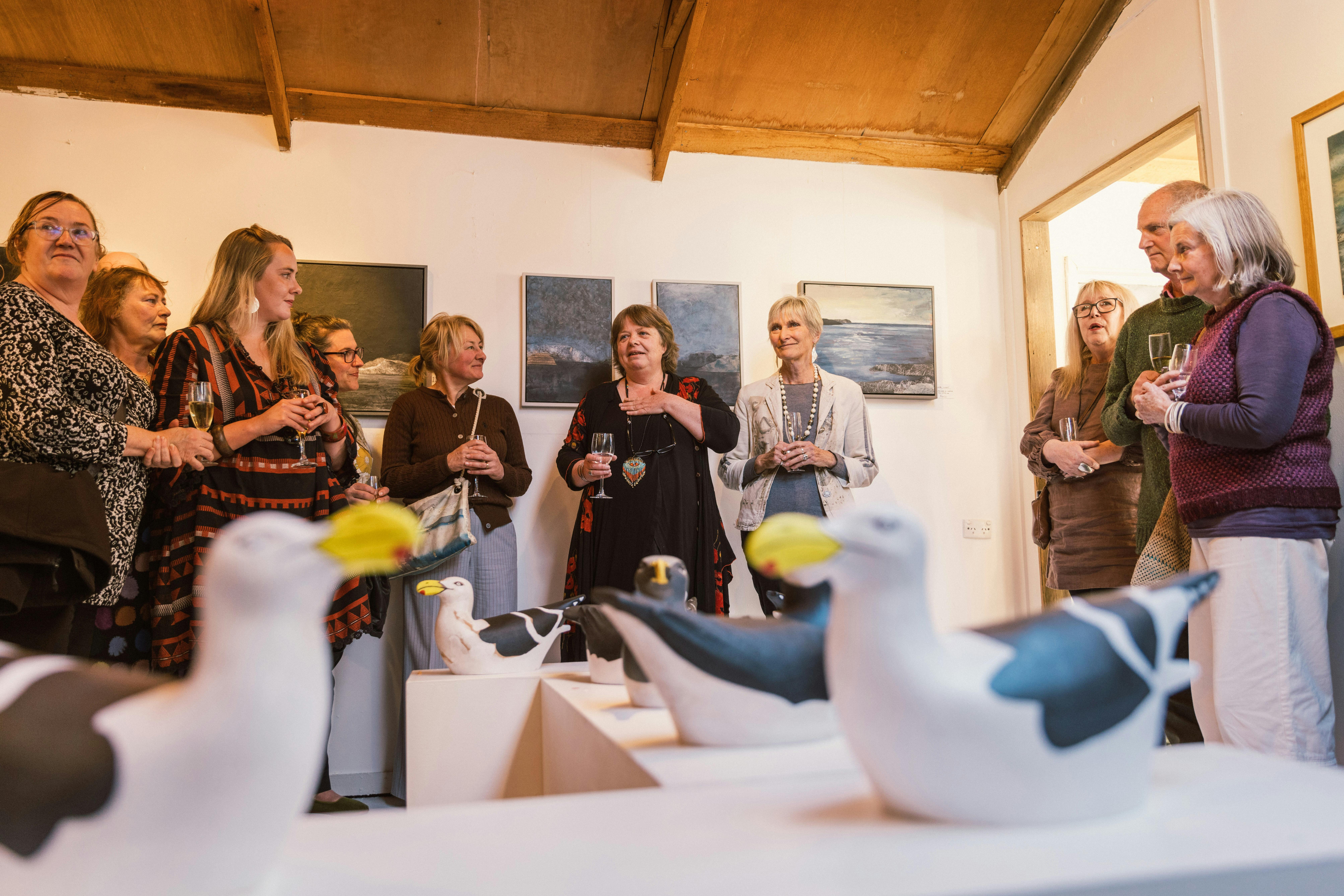 A group of people inside a seaside art gallery.
