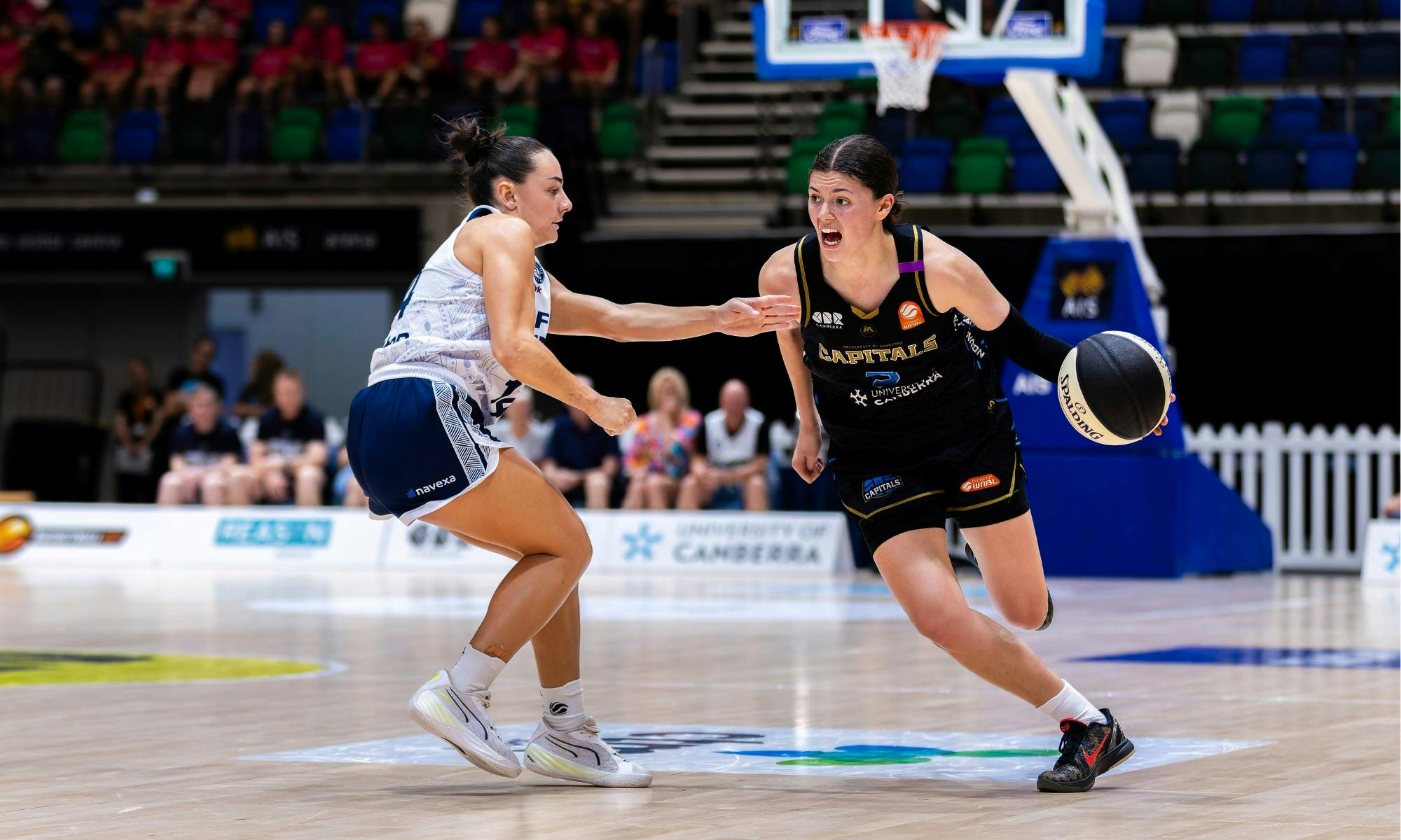 UC Capitals player driving to the basket for a layup during a WNBL game.