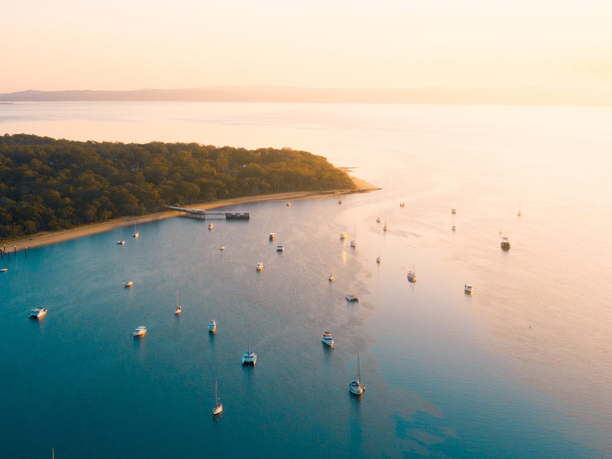 Aerial view of Coochiemudlo Island jetty with boats in calm Redlands Coast waters