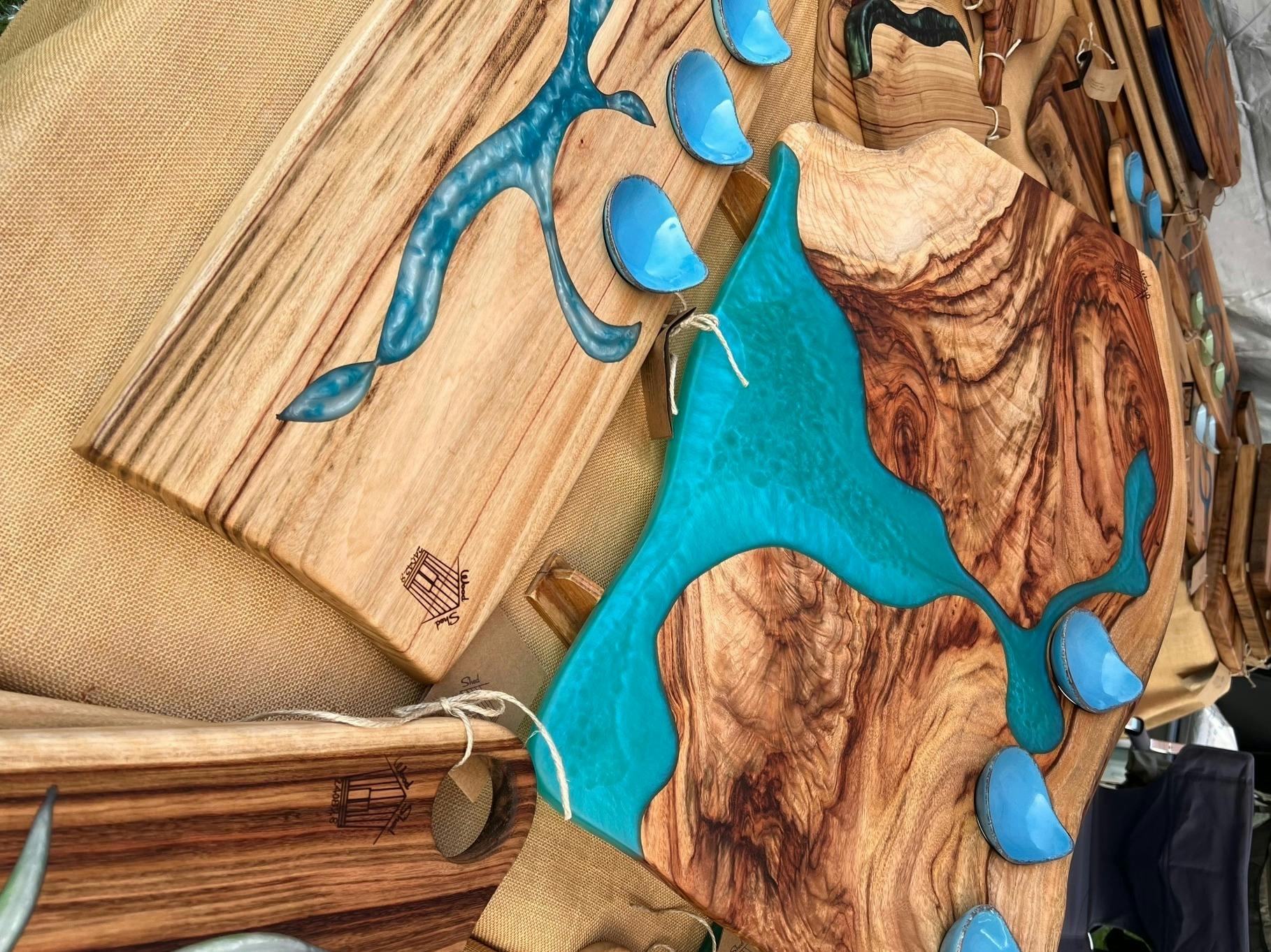 Handmade blue resin & wood chopping boards at a market stall.