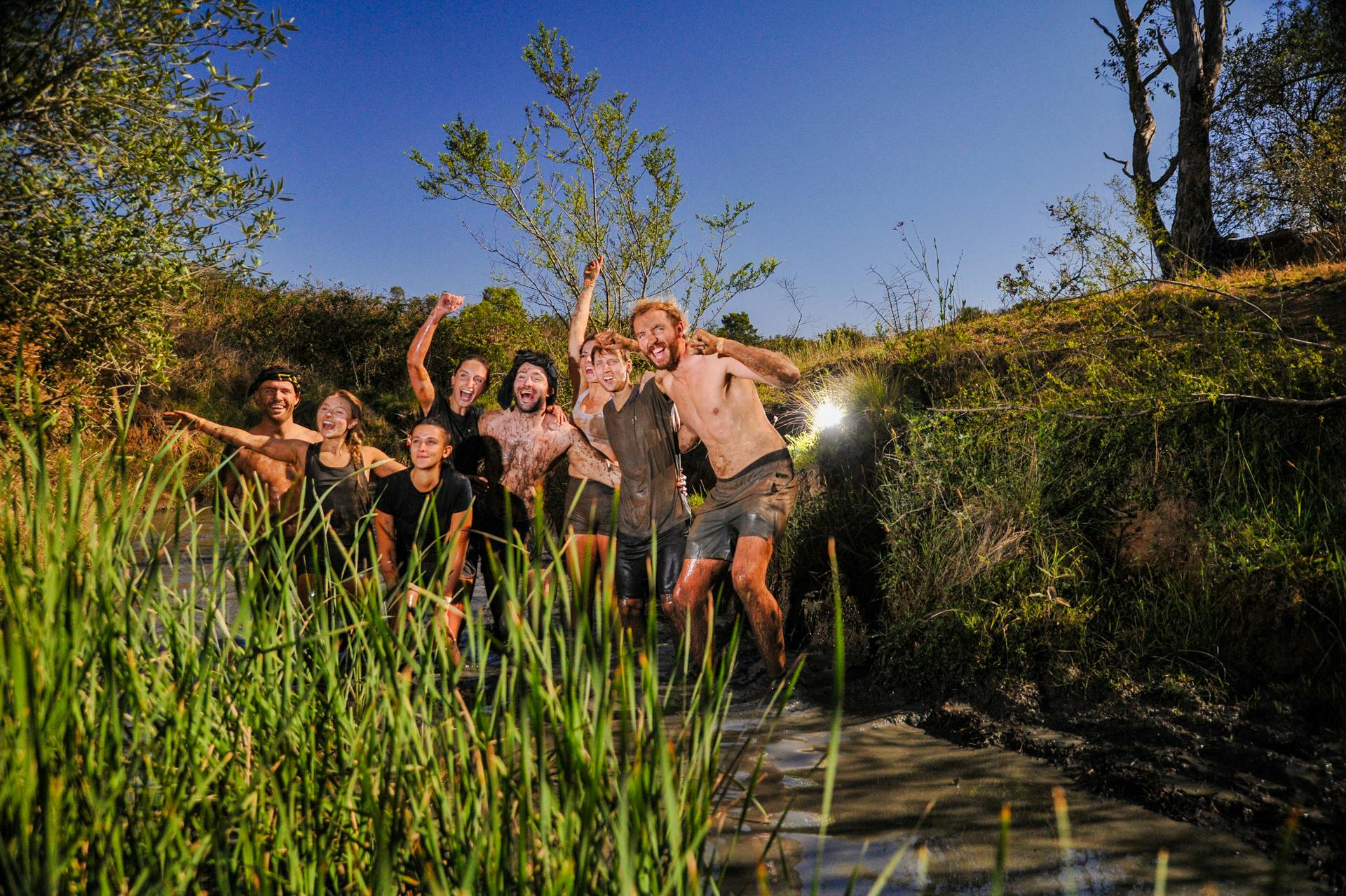 Team of Mudders traversing a rivulet