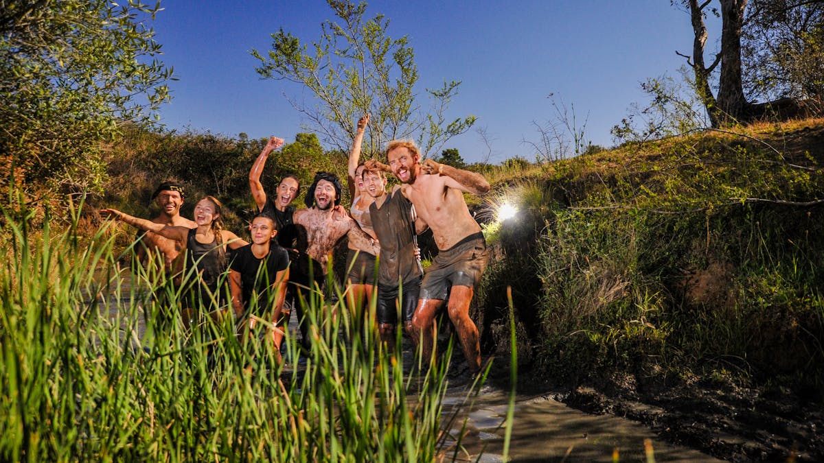Team of Mudders traversing a rivulet
