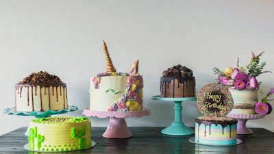 Line of decorated cakes of all colours and shapes.
