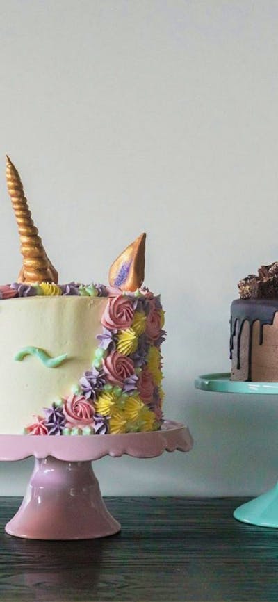 Line of decorated cakes of all colours and shapes.