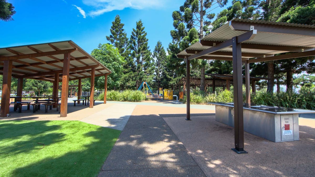 Two picnic table shelters beside grass