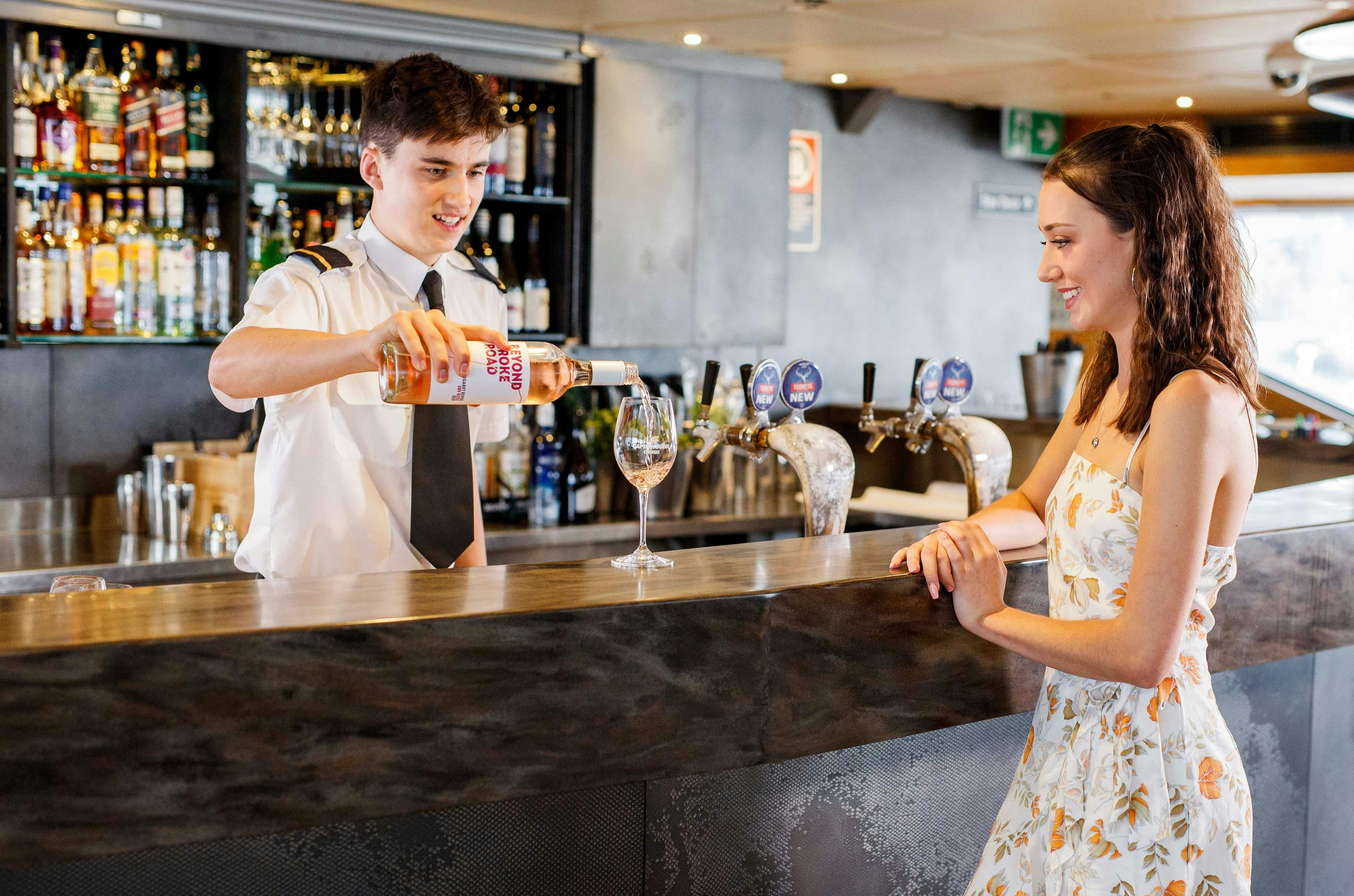 Steward gießt Wein vor Mädchen