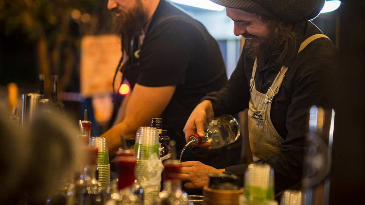 Bartender pouring drink at Milton by Moonlight stall.