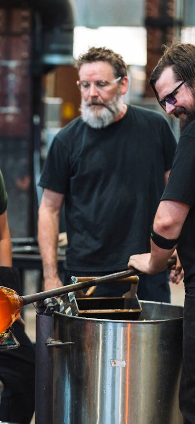 Artists glass blowing in the Hotshop at Canberra Glassworks