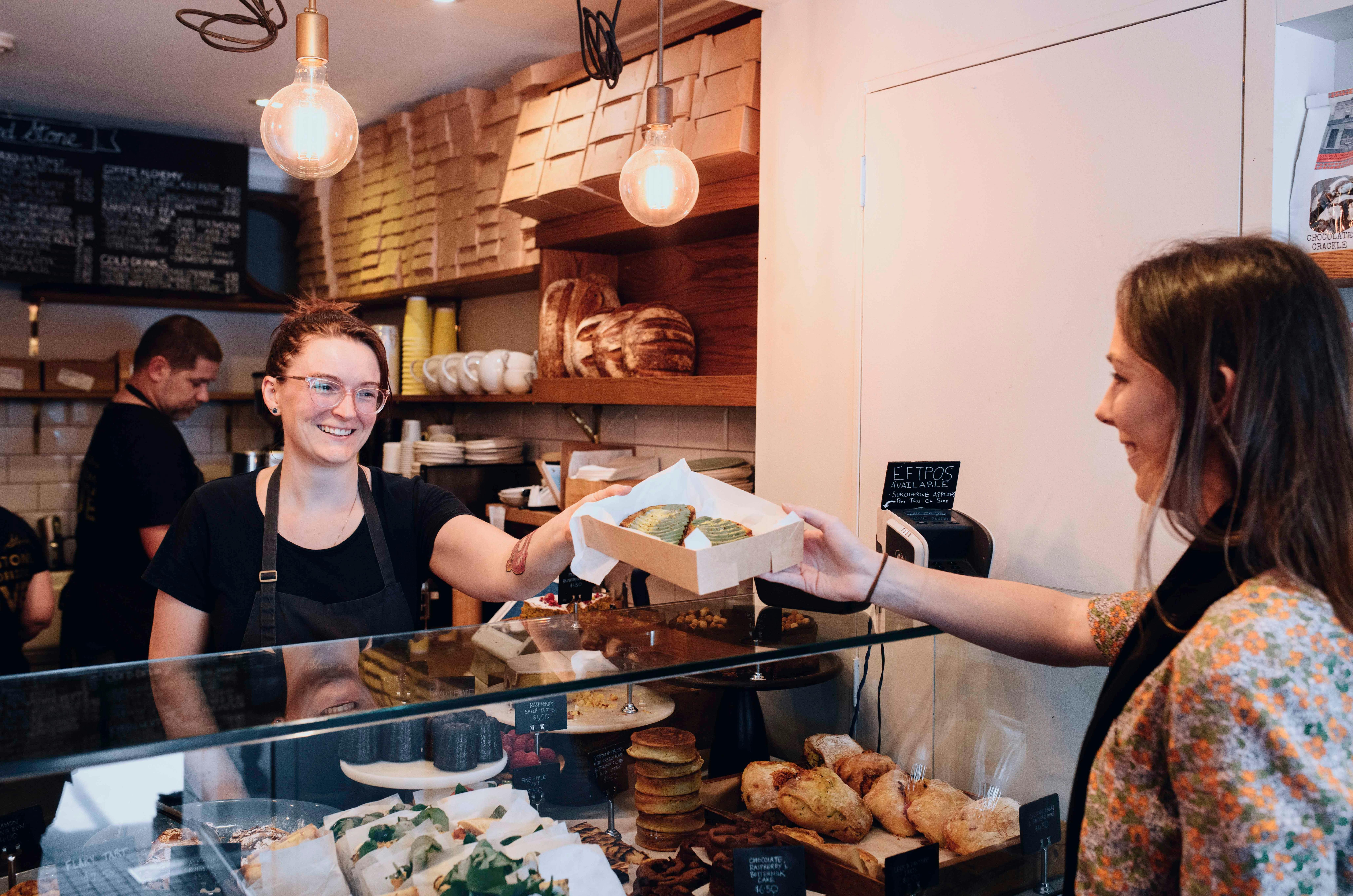 Woman purchasing baked goods at Flour and Stone bakery on Riley Street, Woolloomooloo