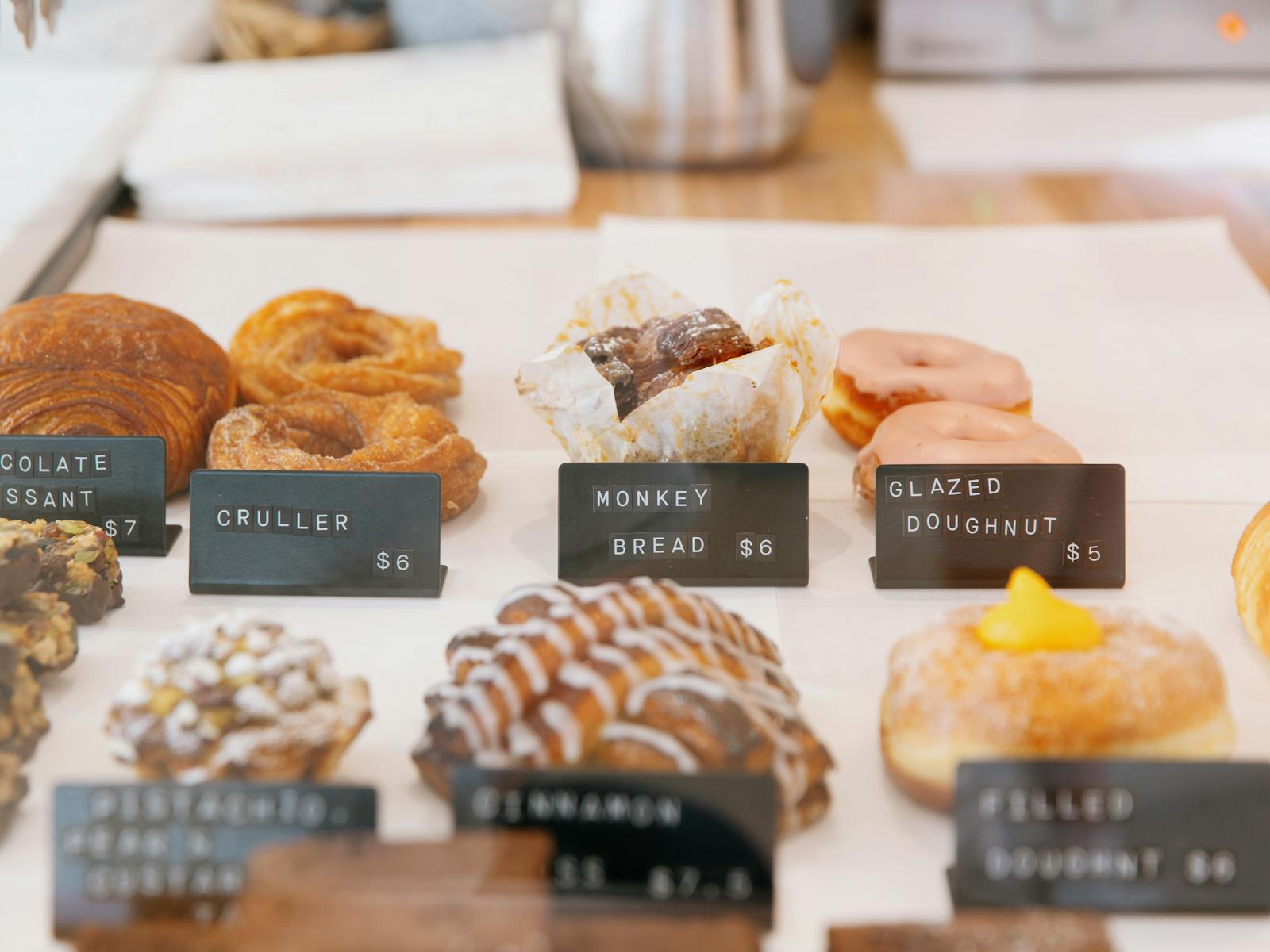 A selection of pastries and sweets including a glazed donut, cruller and chococolate croissant.