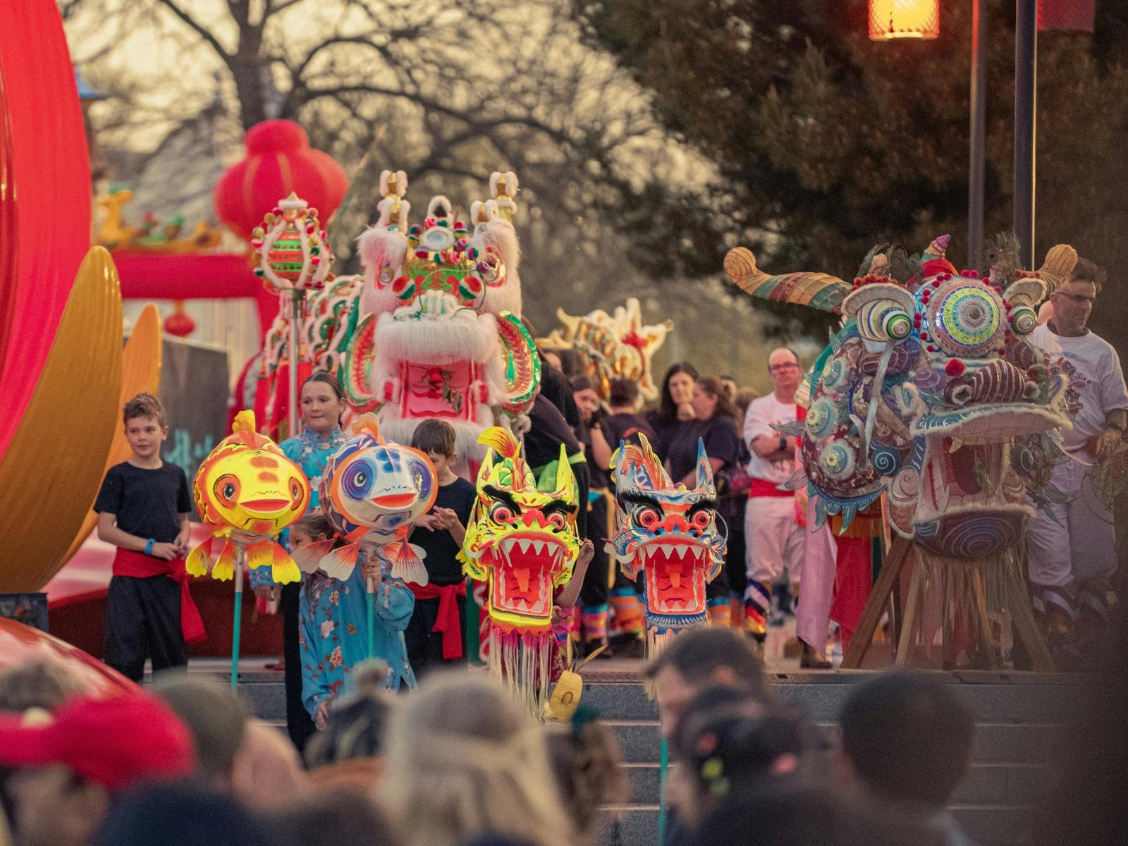 Traditional Chinese dragon and fish puppets on display with a large crowd viewing