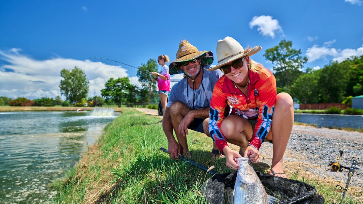 Two fishermen with a barra in the net