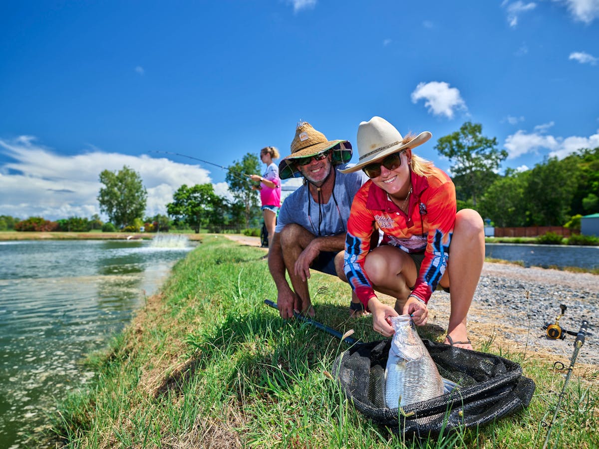 Two fishermen with a barra in the net