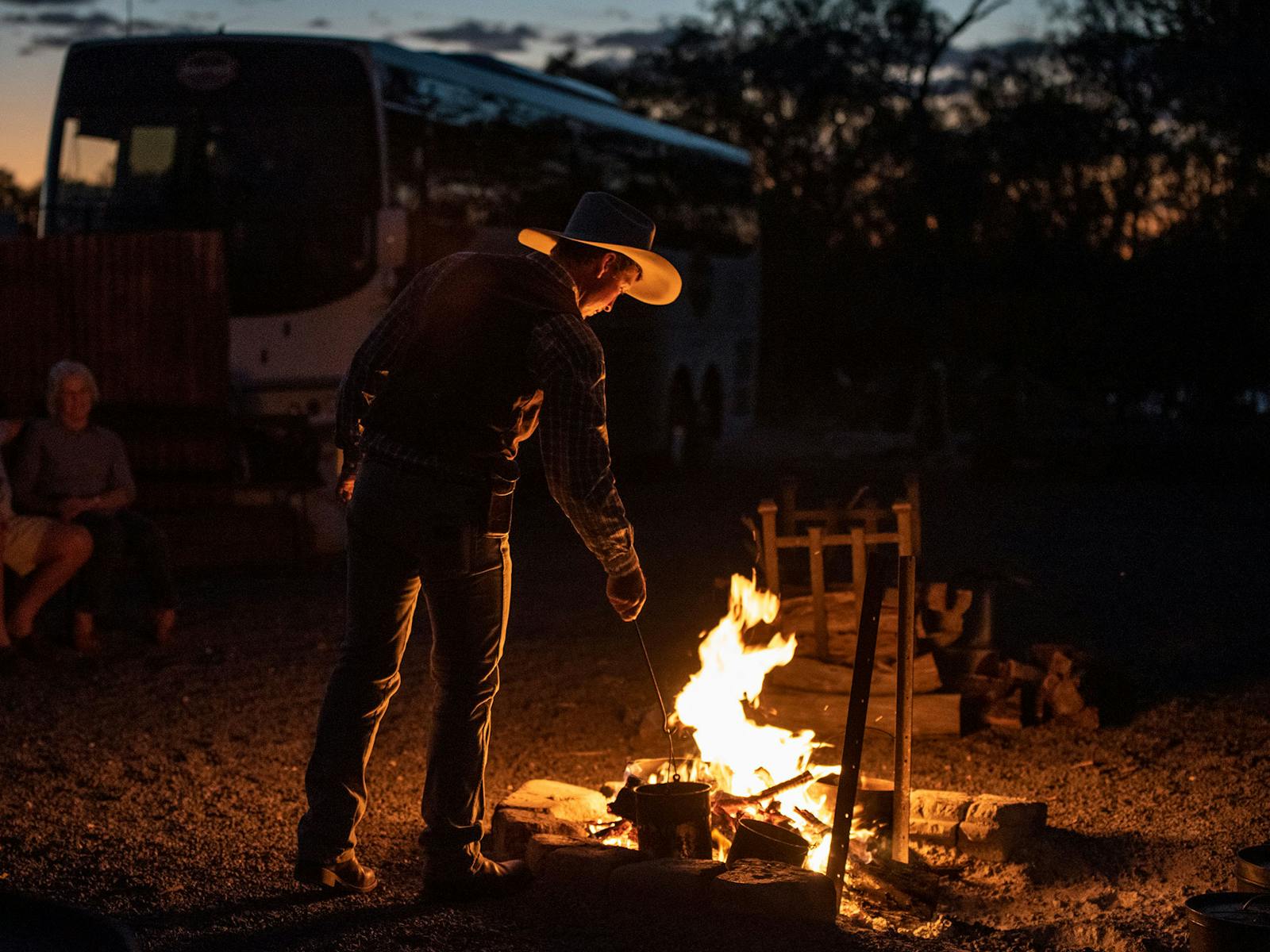 Young stockman, Jeremy Kinnon stoking the camp fire