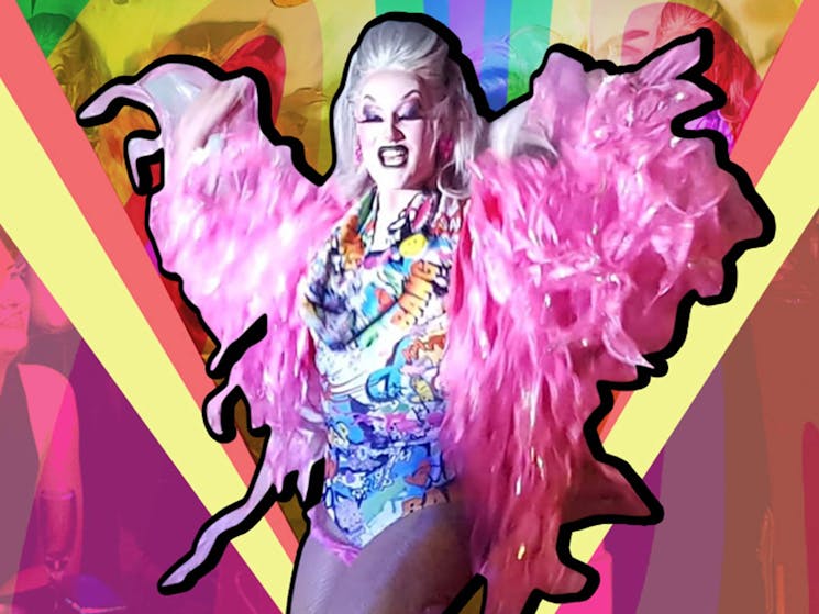 Drag Queen in a pink flouncy shawl in front of graphic audience