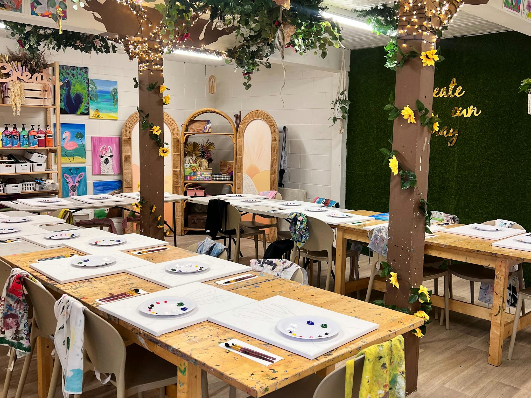 A beautiful setting of art tables with paint palettes and paint on tables ready for the start class A beautiful setting of art tables with paint palettes and paint on tables ready for the start class