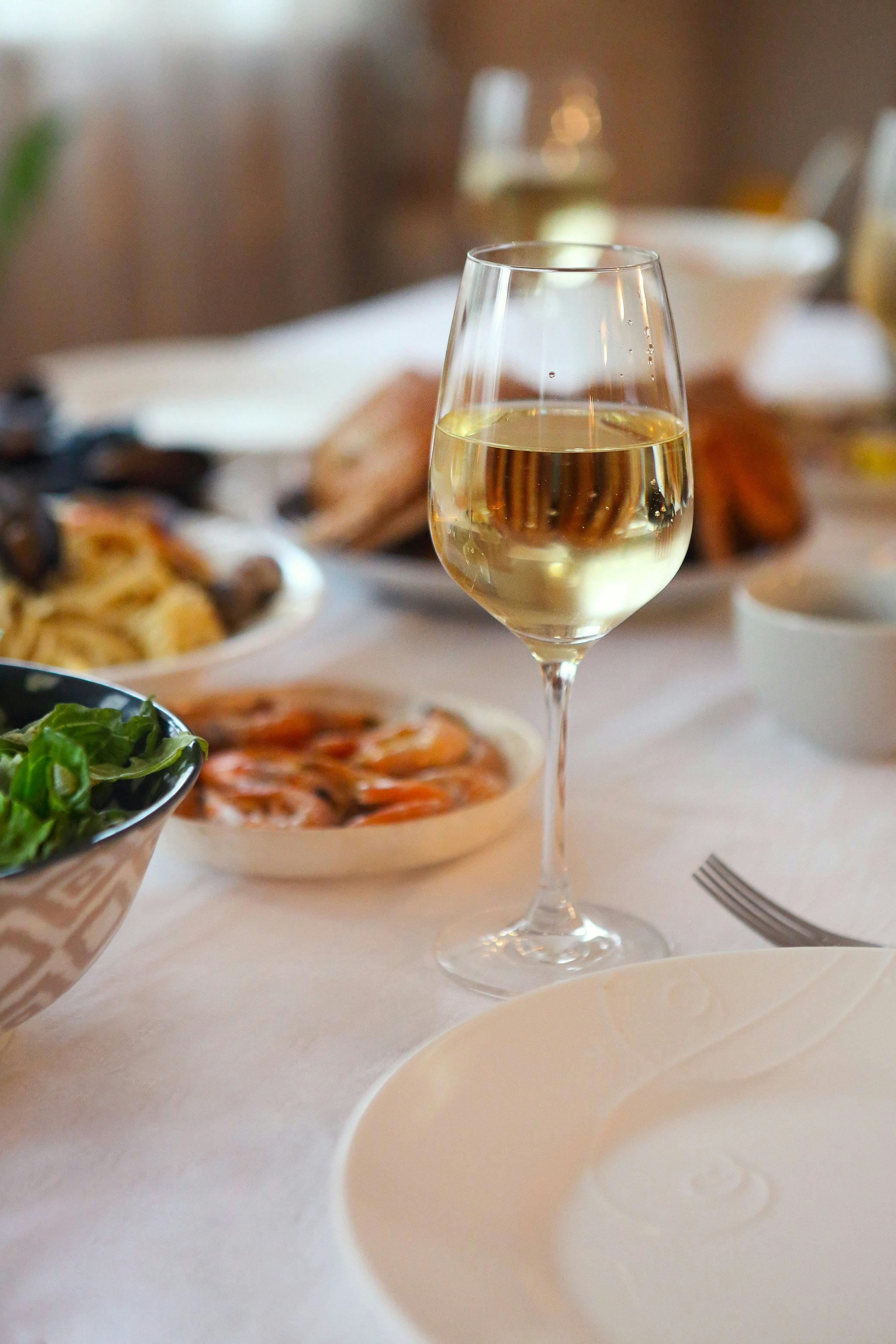 Glass of white wine on a table with food