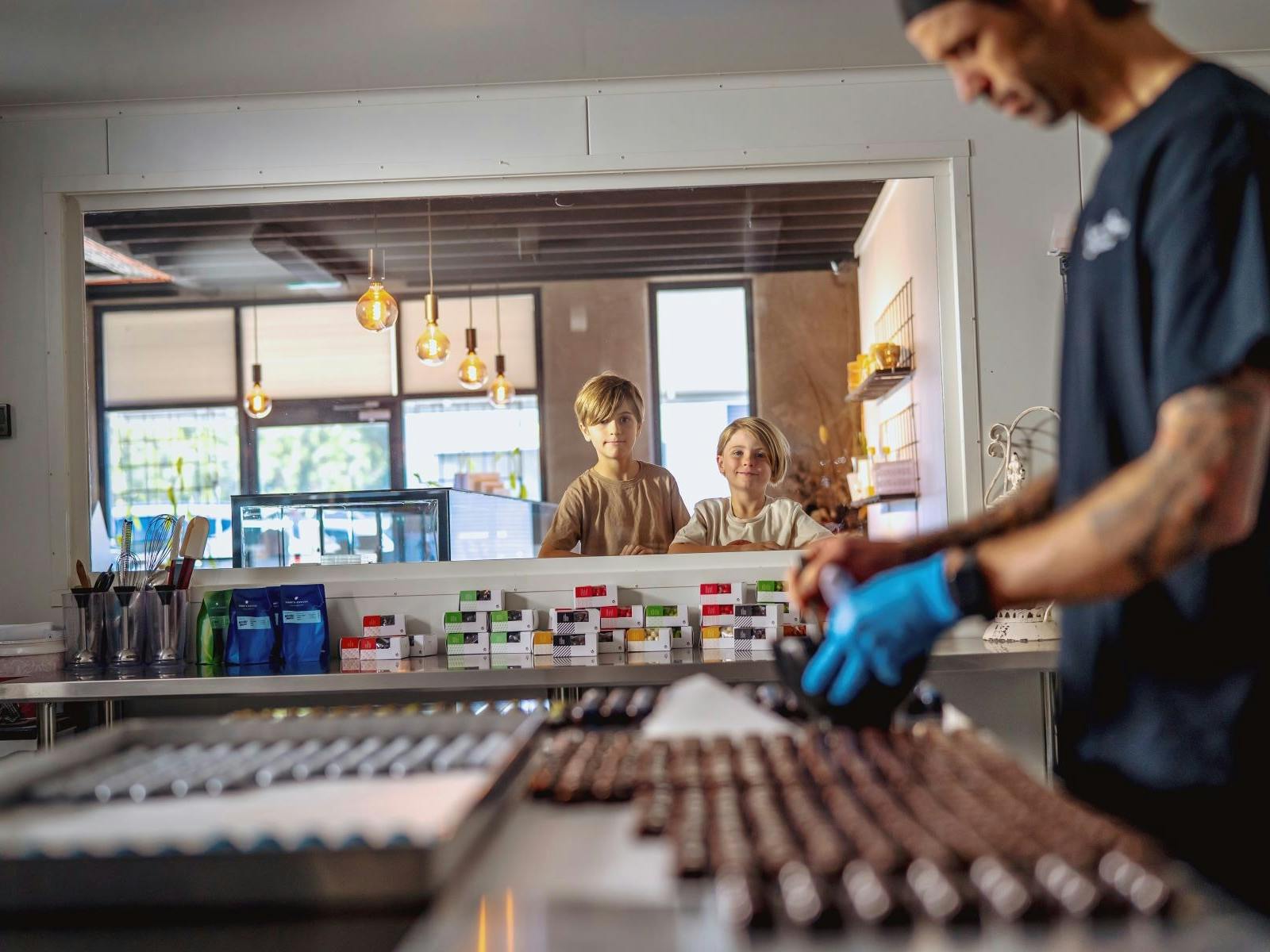 Kids looking through window watching chocolatier