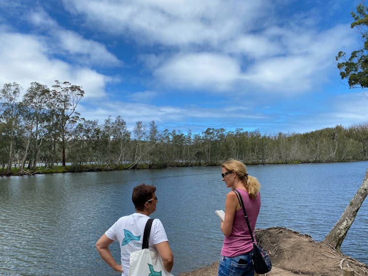 Guide and visitor at rivers edge.