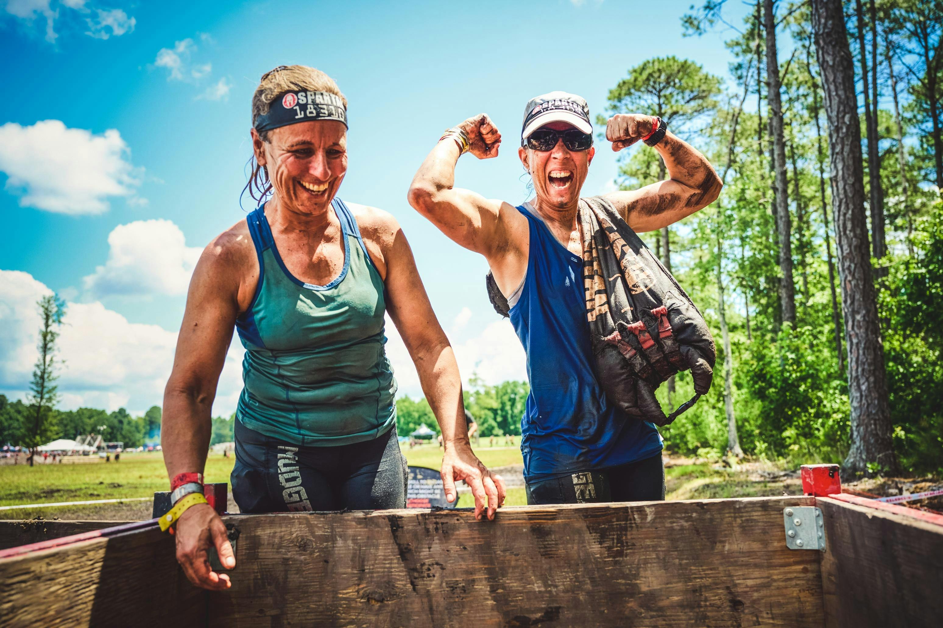 Two people celebrate getting over an obstacle.