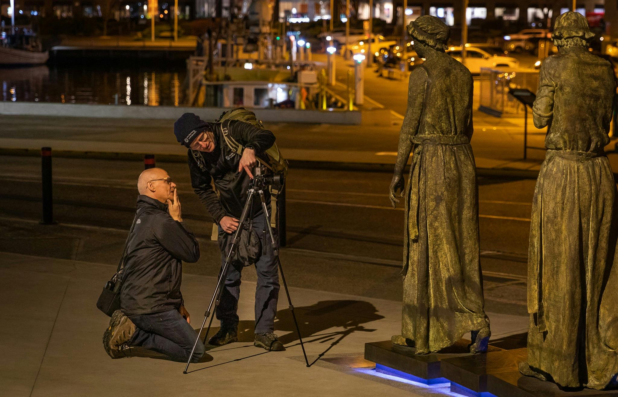 a photography tutor provides instruction to a photographer in the low light of night time