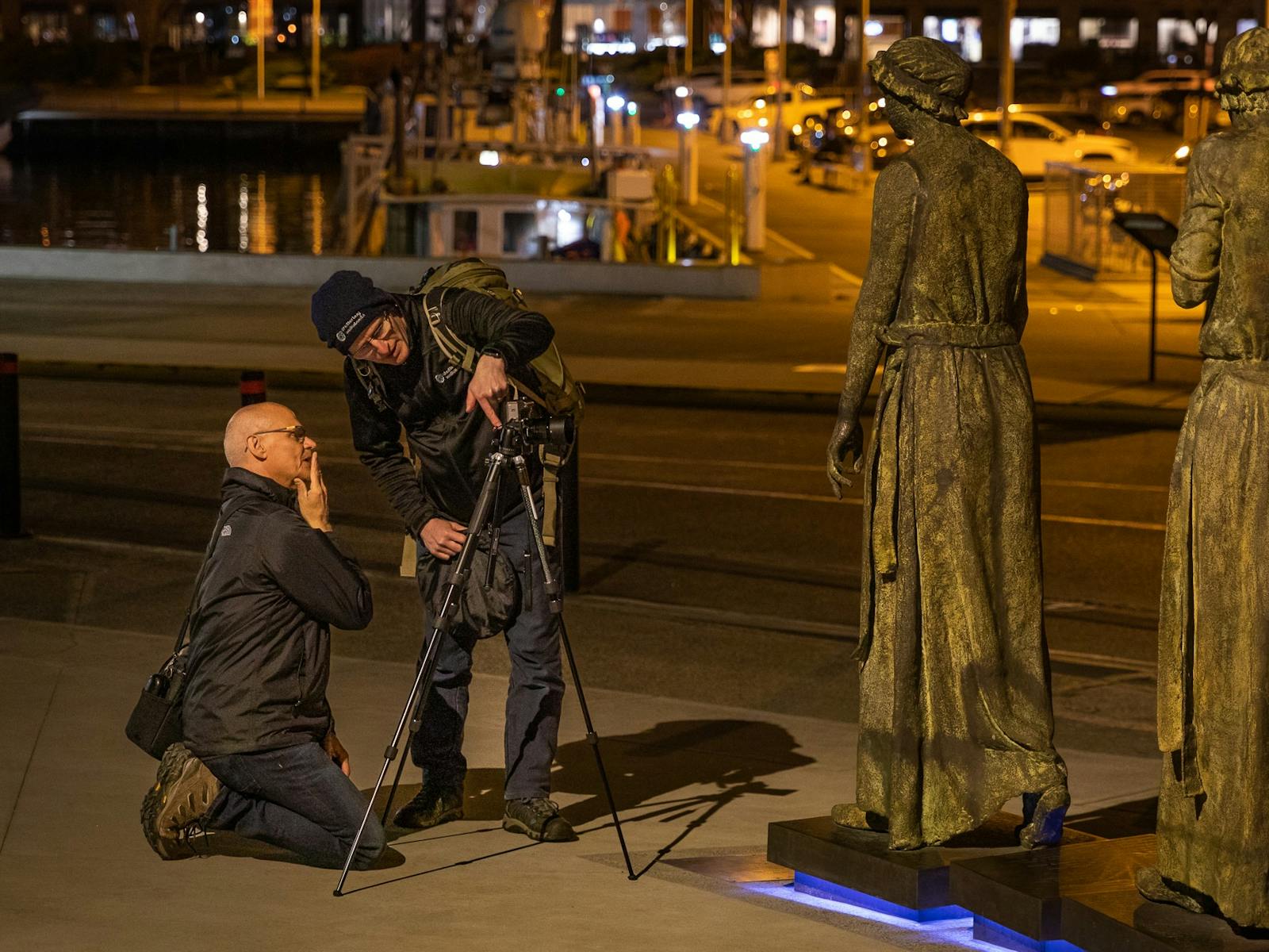 a photography tutor provides instruction to a photographer in the low light of night time
