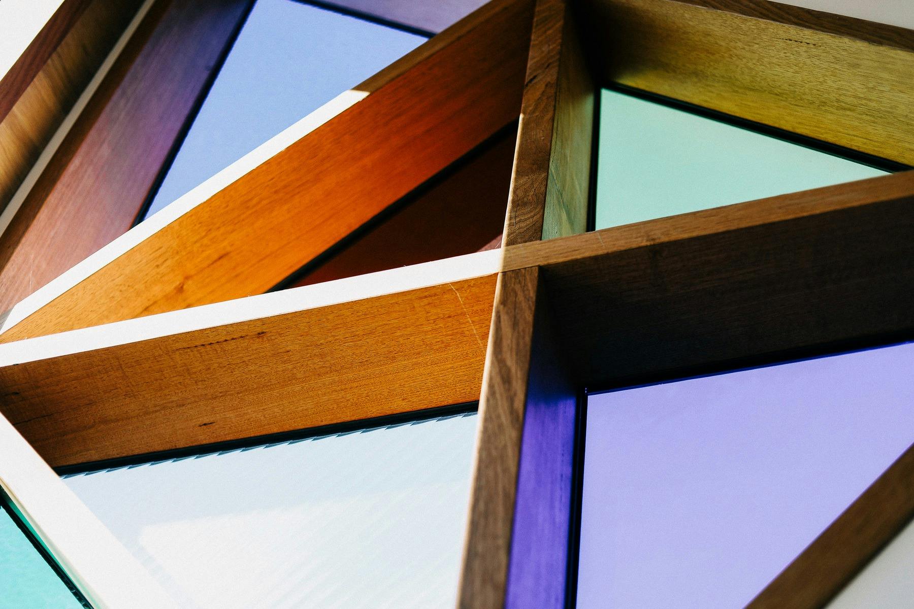 Triangle stained glass windows in purple, blue, red, and green glass