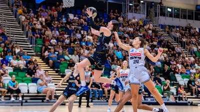 UC Capitals player driving to the basket for a layup during a WNBL game against Sydney Flames.