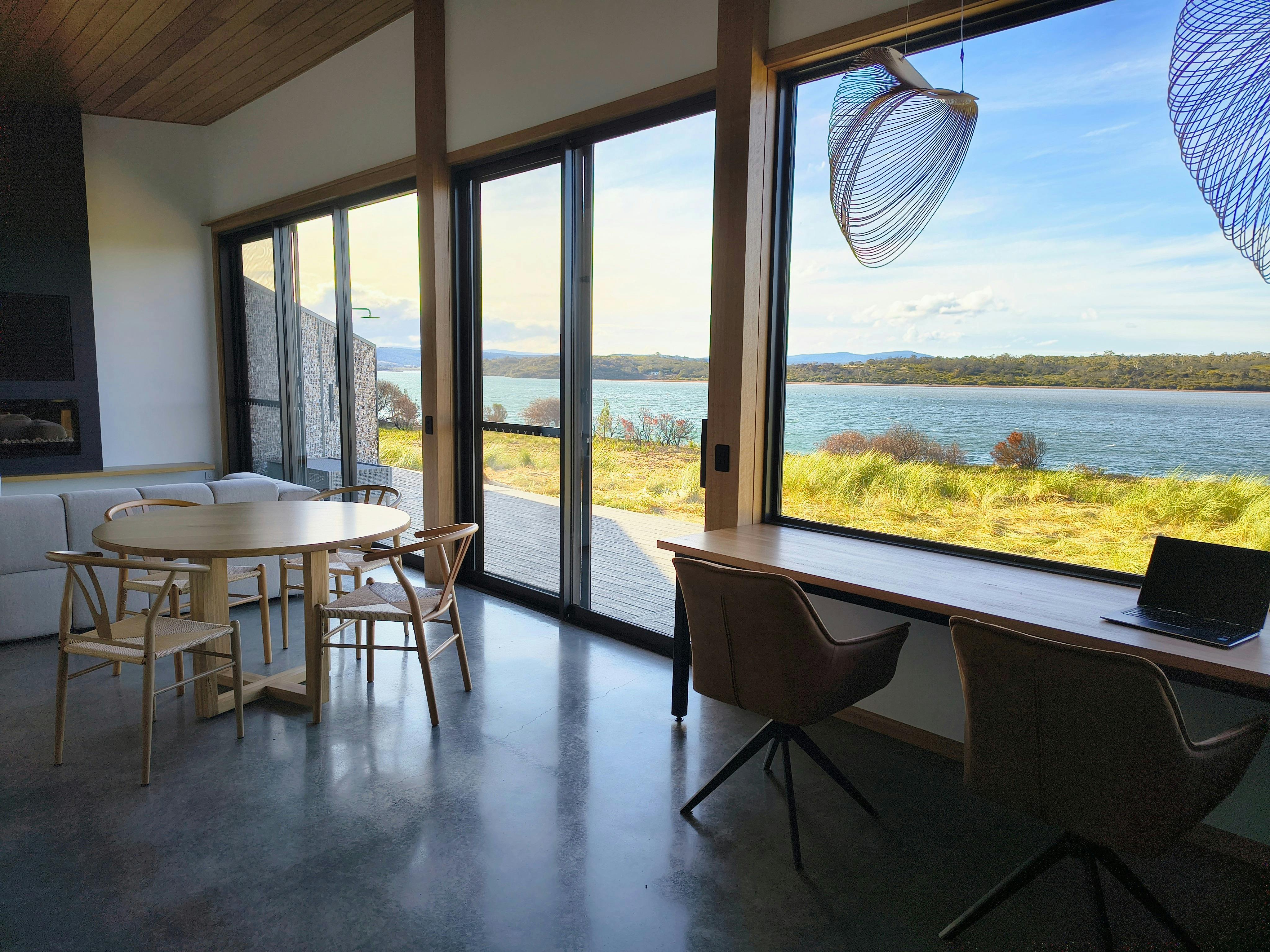Sand Shacks Dolphin Sands living room offers views of Swan River, relaxing seating.
