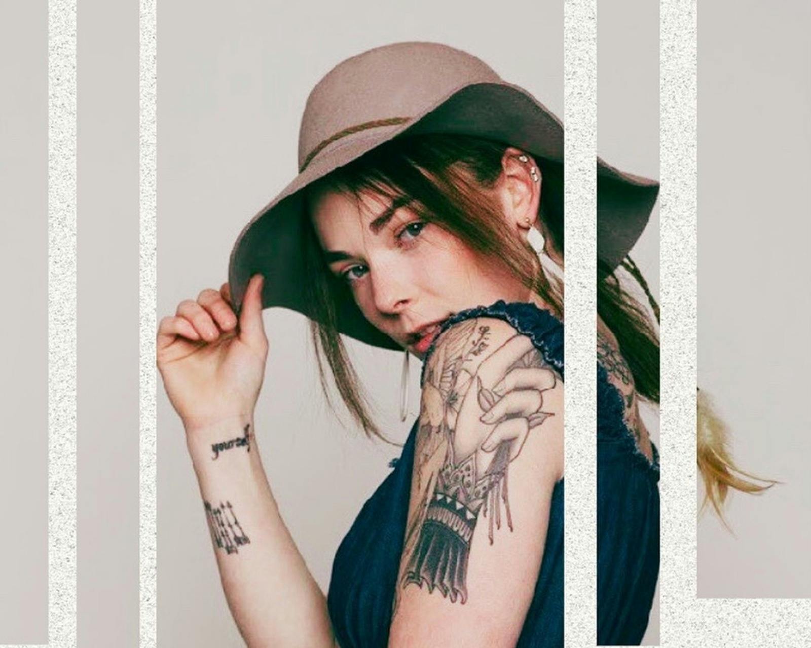 a lady looking over her shoulder wearing a hat