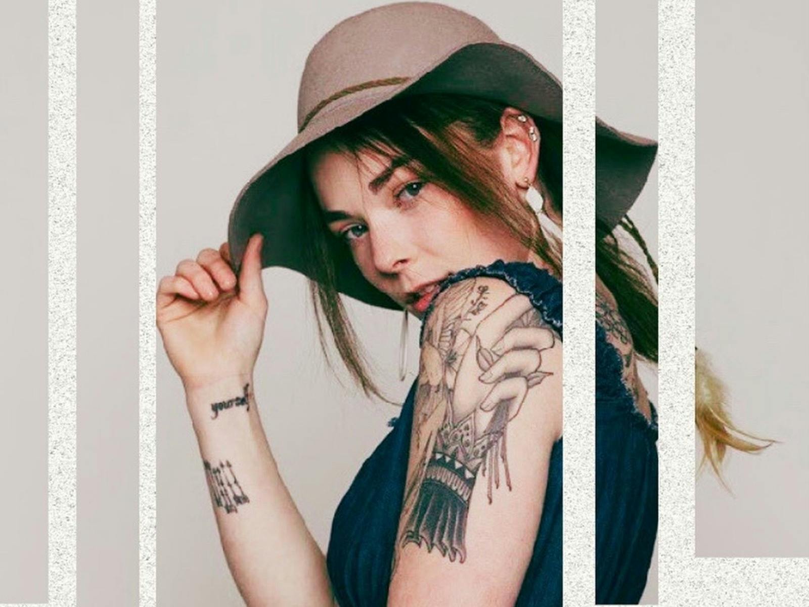 a lady looking over her shoulder wearing a hat