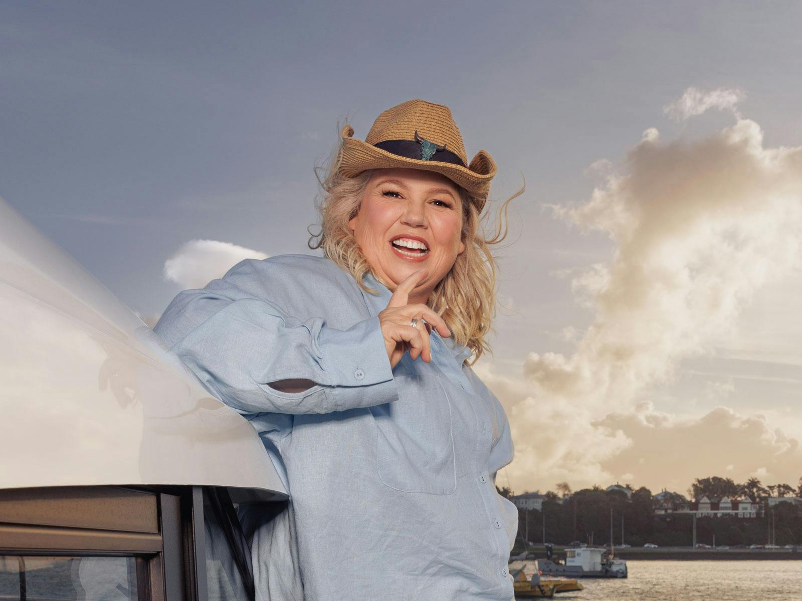 Urzila Carlson is pictured on a yacht smiling wearing a blue shirt and a brown hat Urzila Carlson is pictured on a yacht smiling wearing a blue shirt and a brown hat