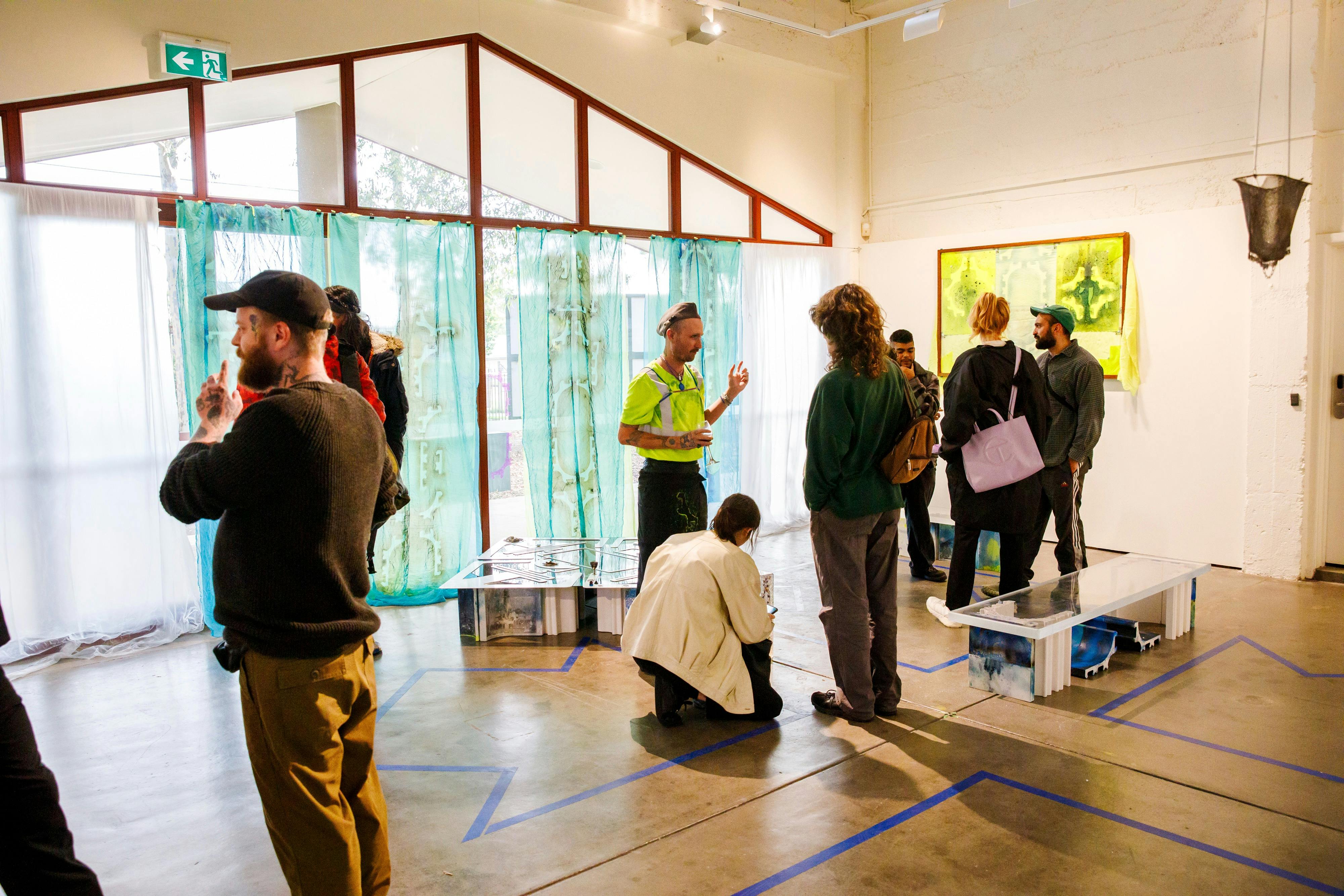 People viewing exhibition in the Atrium at Incinerator Gallery.