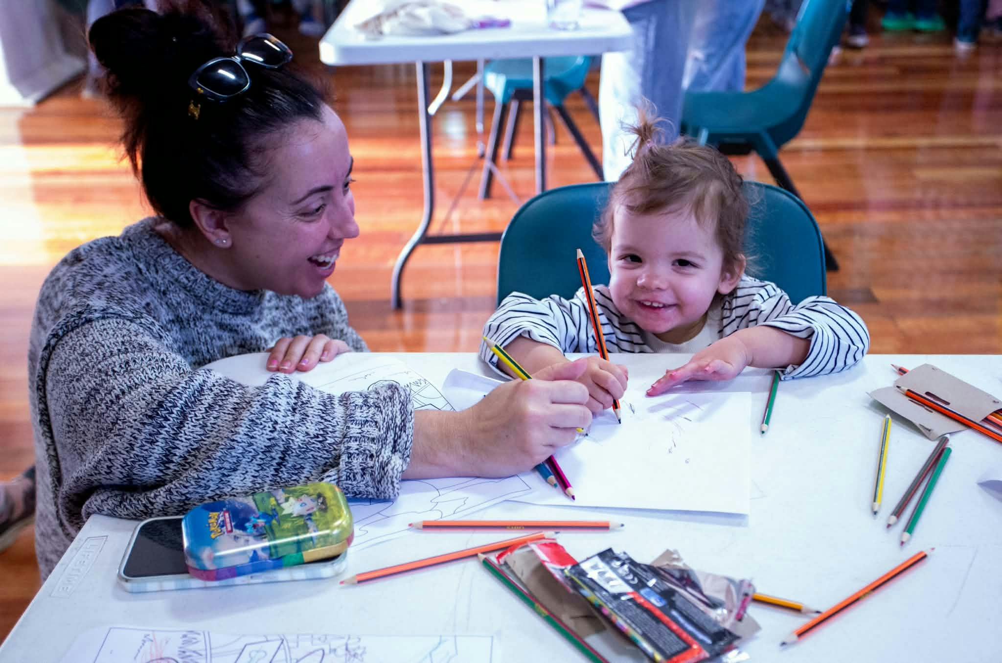 mother and child colouring in, visually happy and excited, enjoying the event
