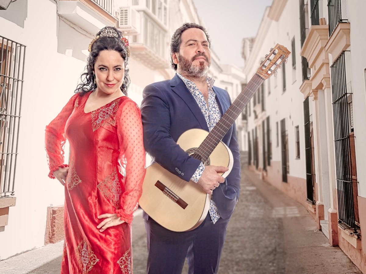 Woman standing next to a man holding guitar