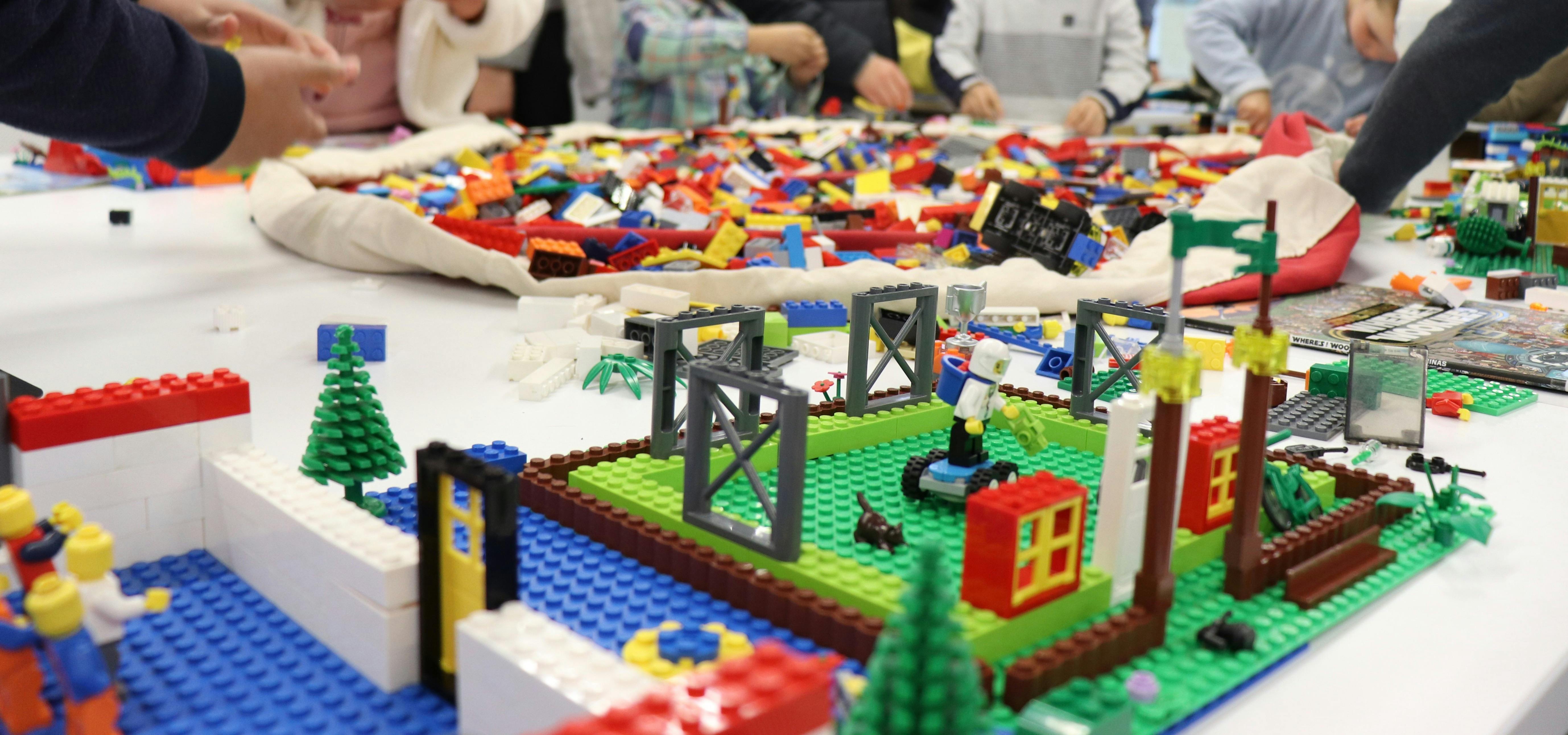 A big pile of lego, kids are in the background playing