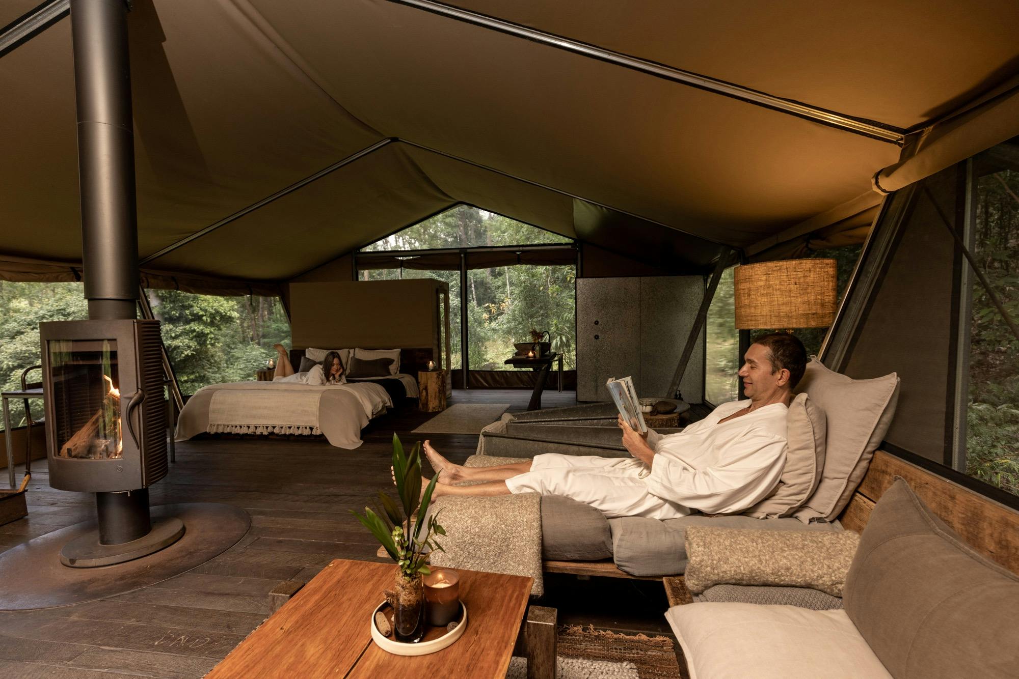 Guest couple relaxing inside safari tent accomodation.