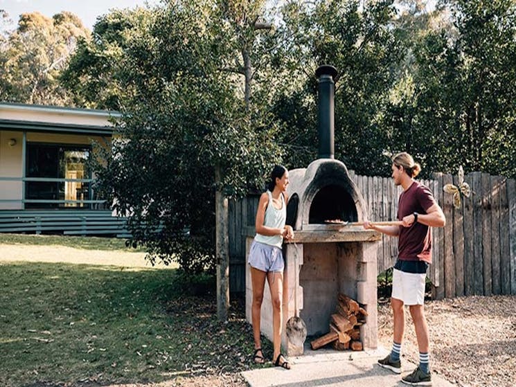 A couple cook a barbecue at Depot Beach cabins, Murramarang National Park. Photo: Melissa Findley/OE