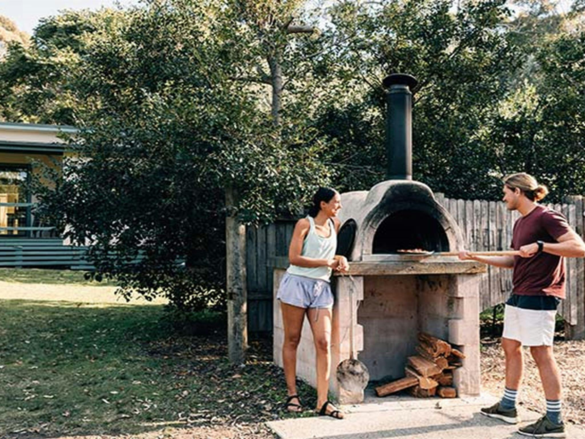 Ein Paar nutzt den Pizzaofen auf dem Campingplatz Depot Beach im Murramarang-Nationalpark. Foto: Melissa