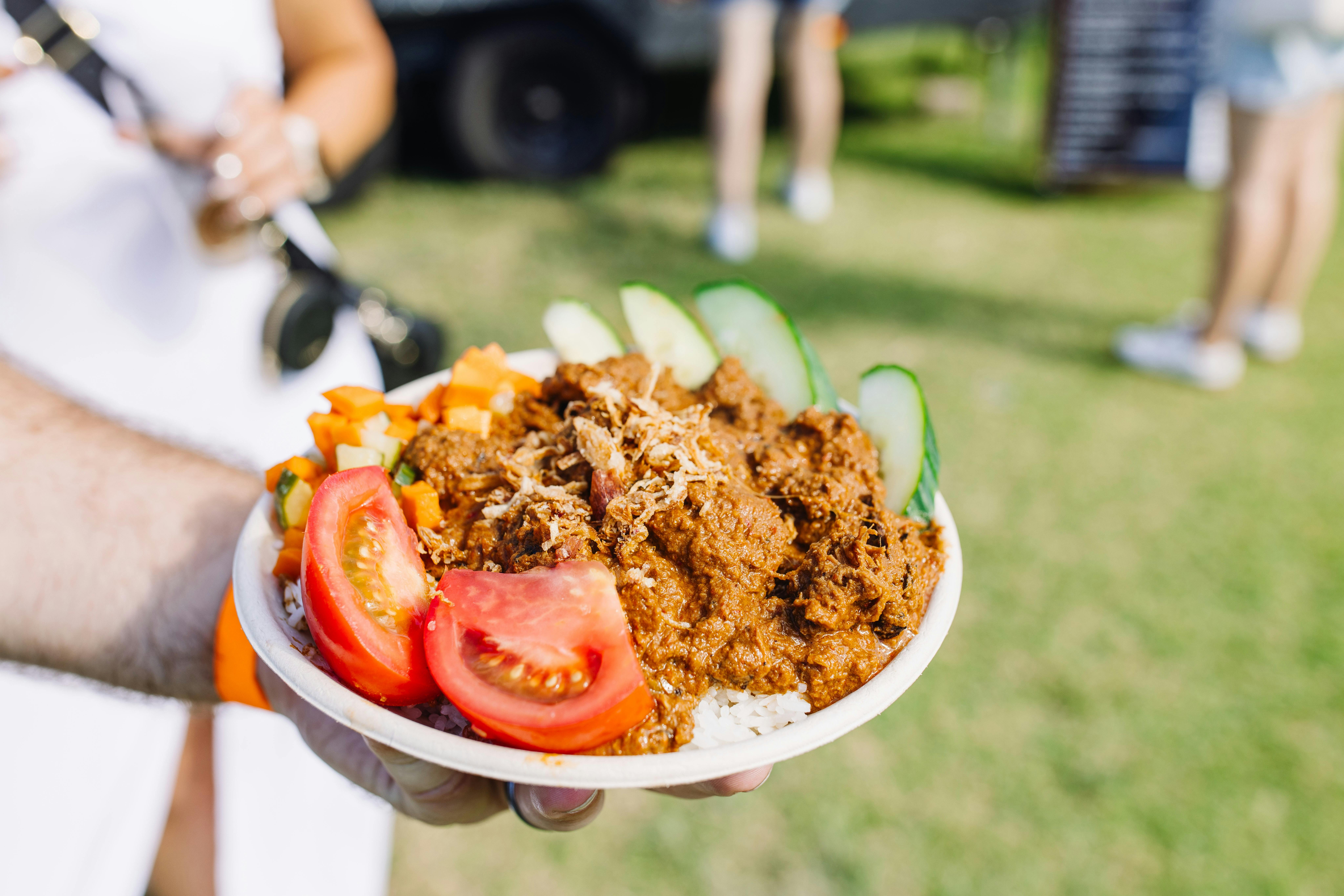 A hand holding a plate of food