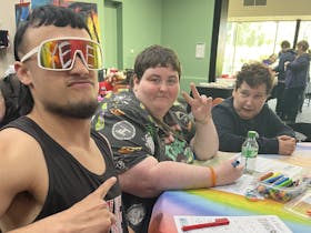 Three people with disabilities sitting at a round table with bright colours