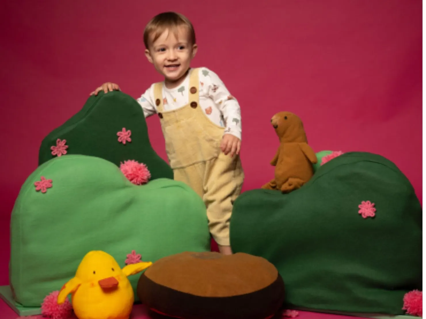 little child with soft toys around hime