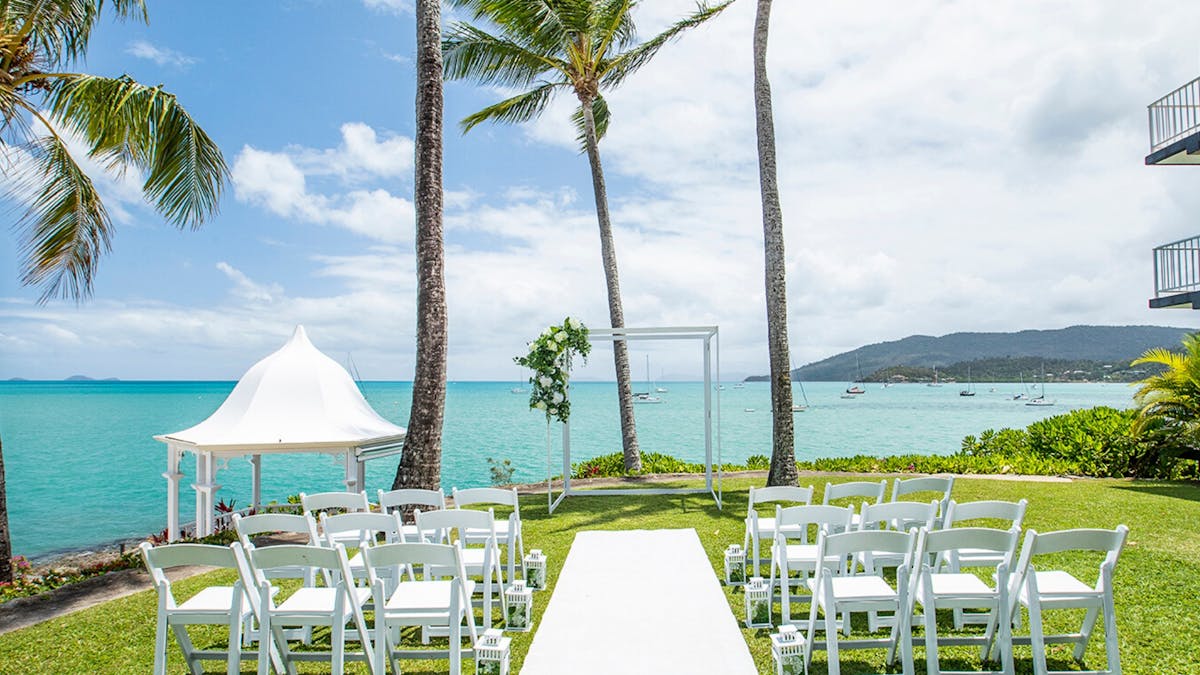 A wedding ceremony set up on The Upper Lawn at Coral Sea Marina Resort
