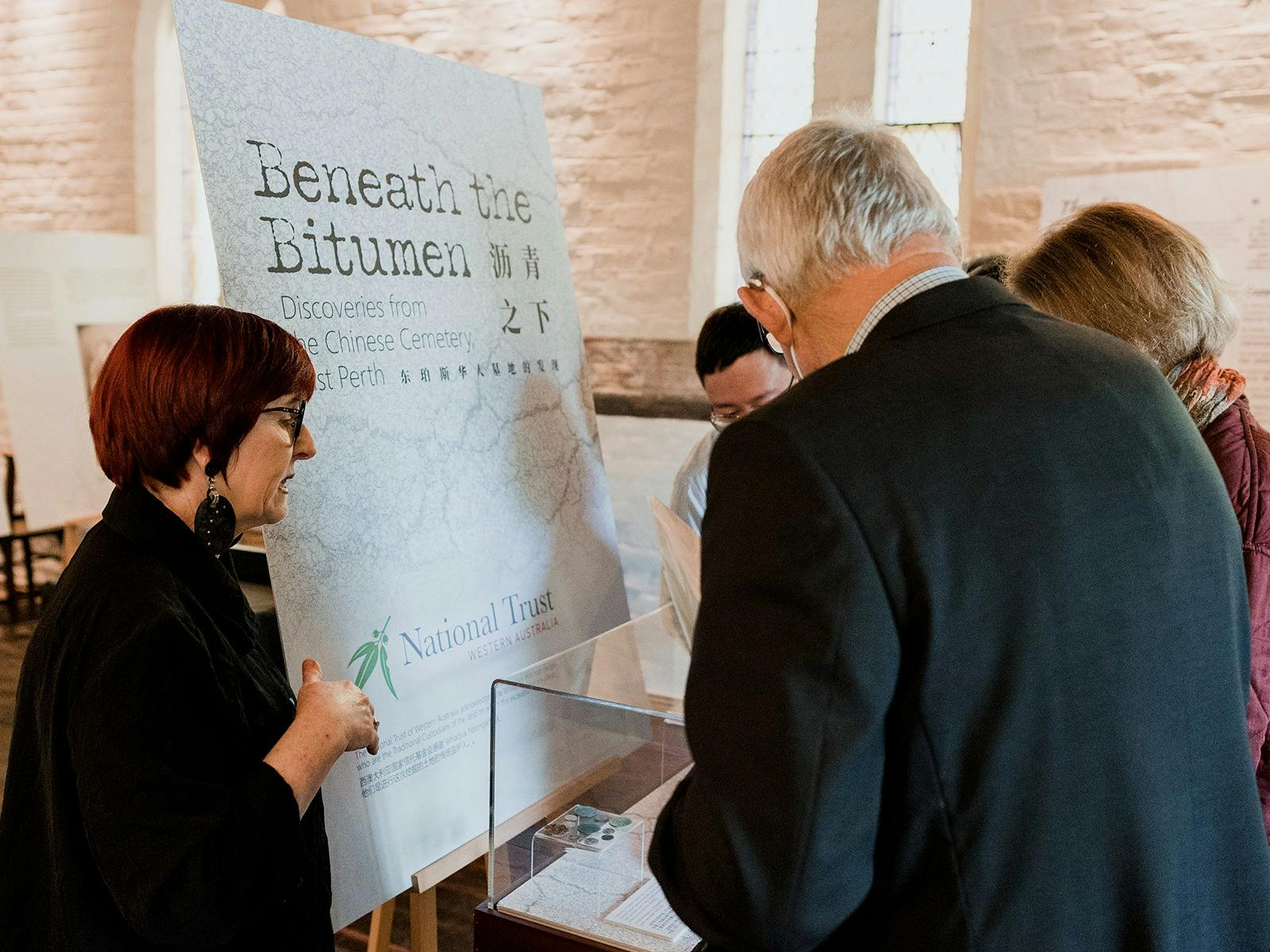 Female curator speaks with exhibition visitors
