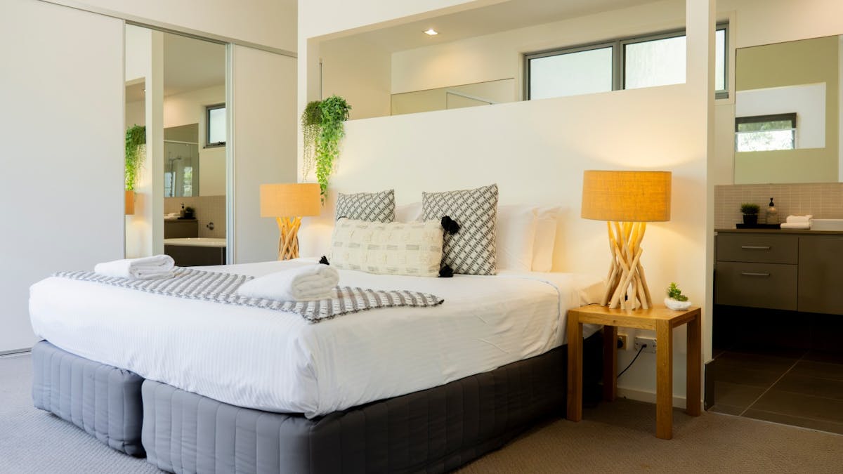 Spacious room with a queen bed, ensuite, large cupboards, and a mirrored wardrobe.