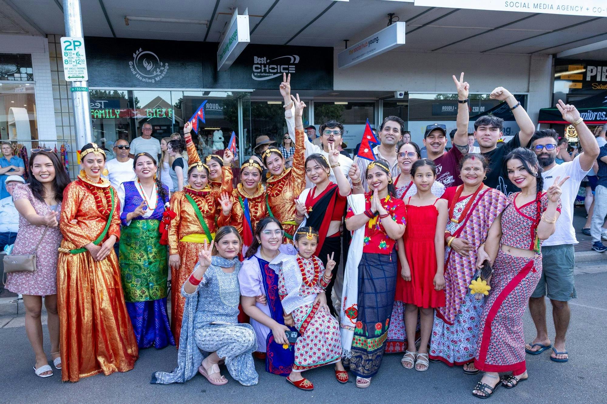 A group photo of festival-goers in cultural attire with big smiles.