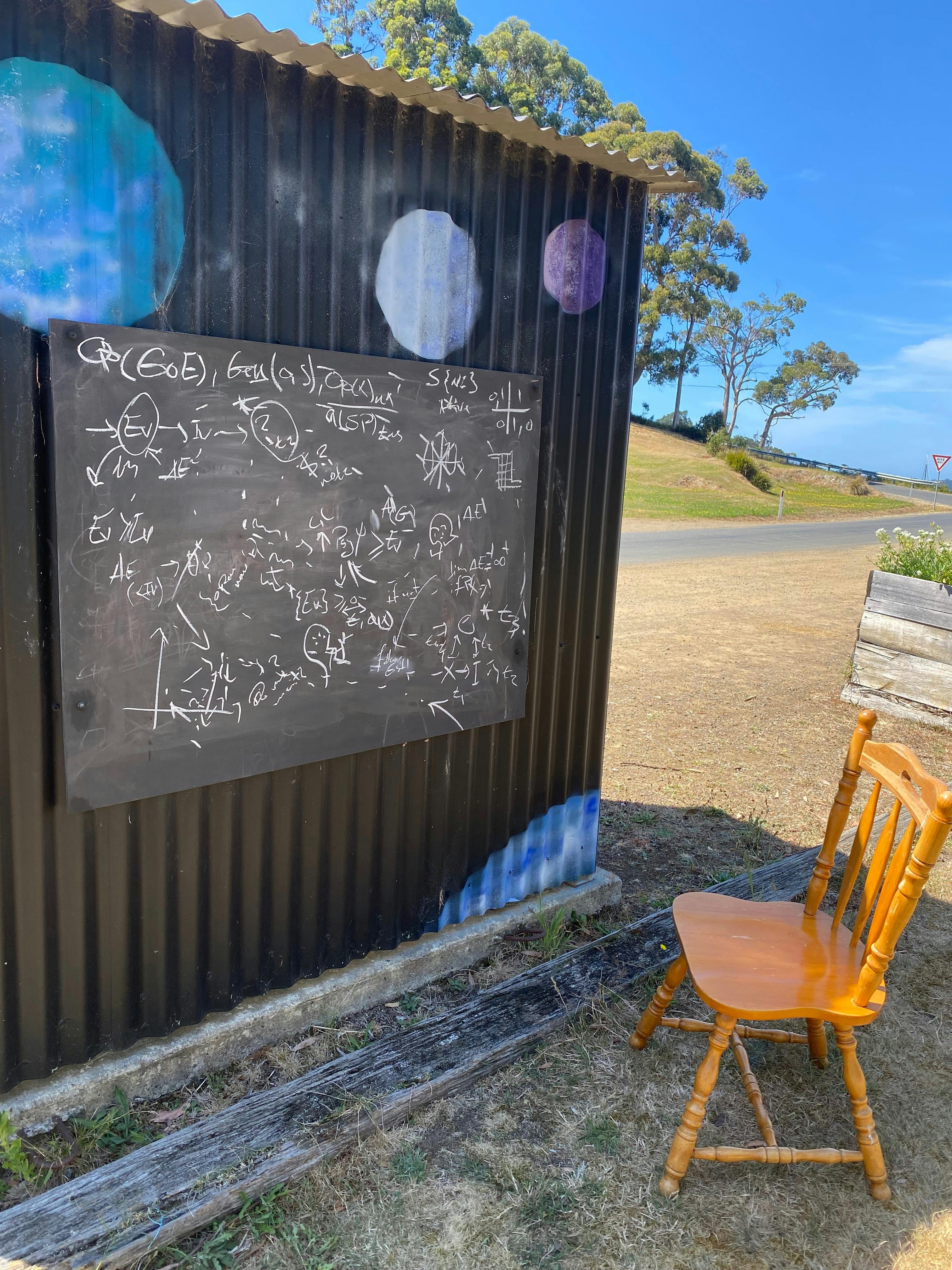 Blackboard with complex calculations on the back of the bus shelter painted with a space mural