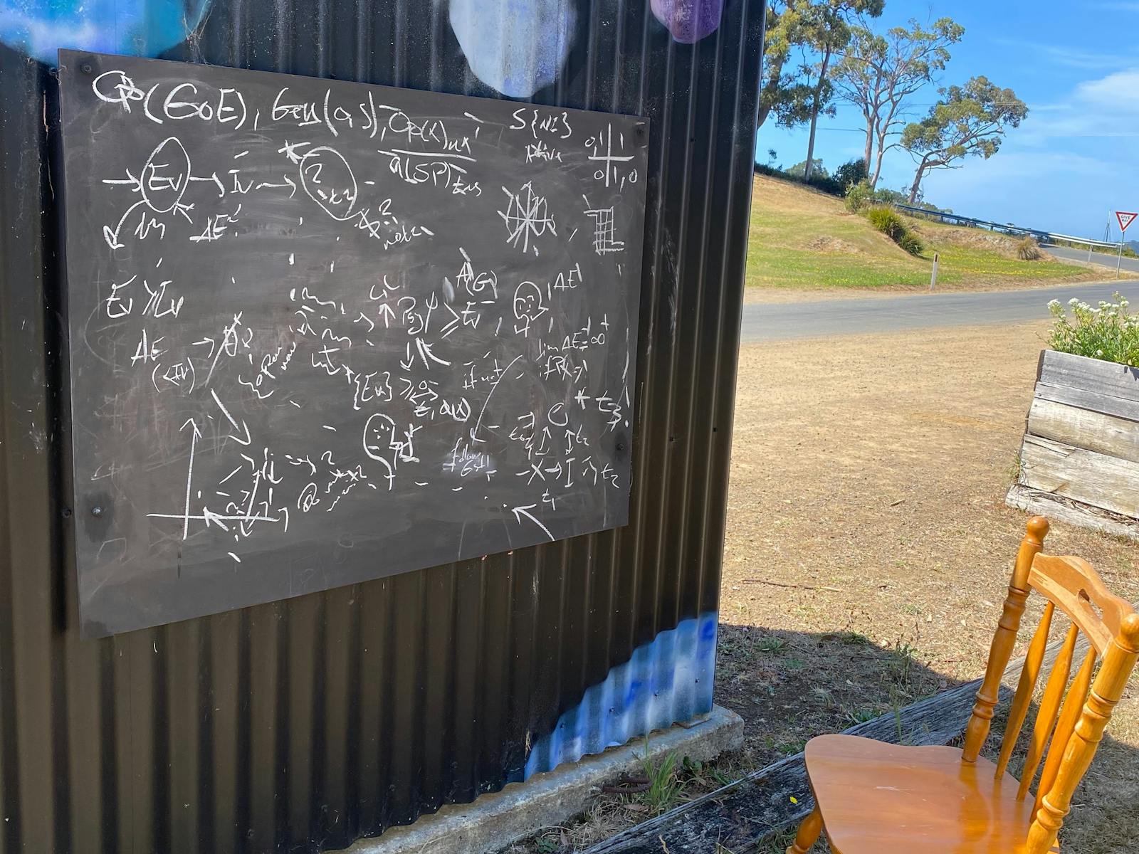Blackboard with complex calculations on the back of the bus shelter painted with a space mural