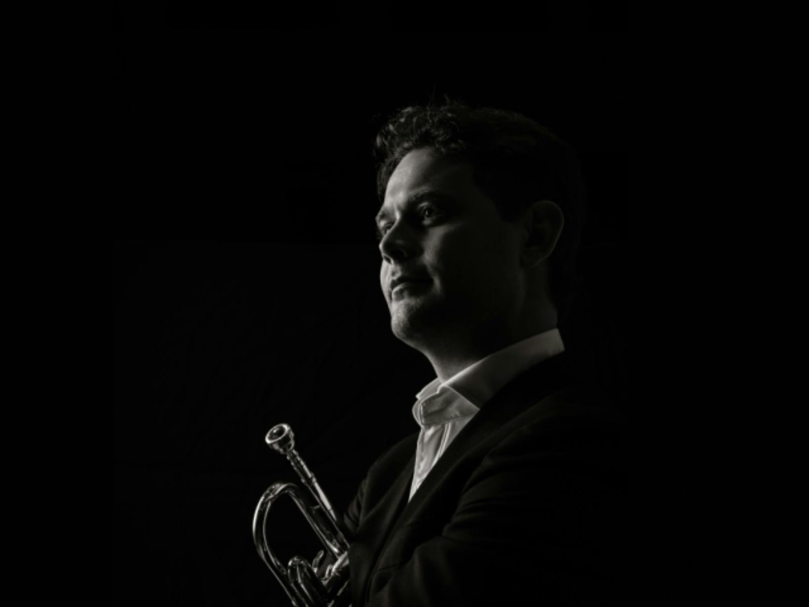 Black-and-white portrait of a trumpet player in profile, looking toward the light Black-and-white portrait of a trumpet player in profile, looking toward the light