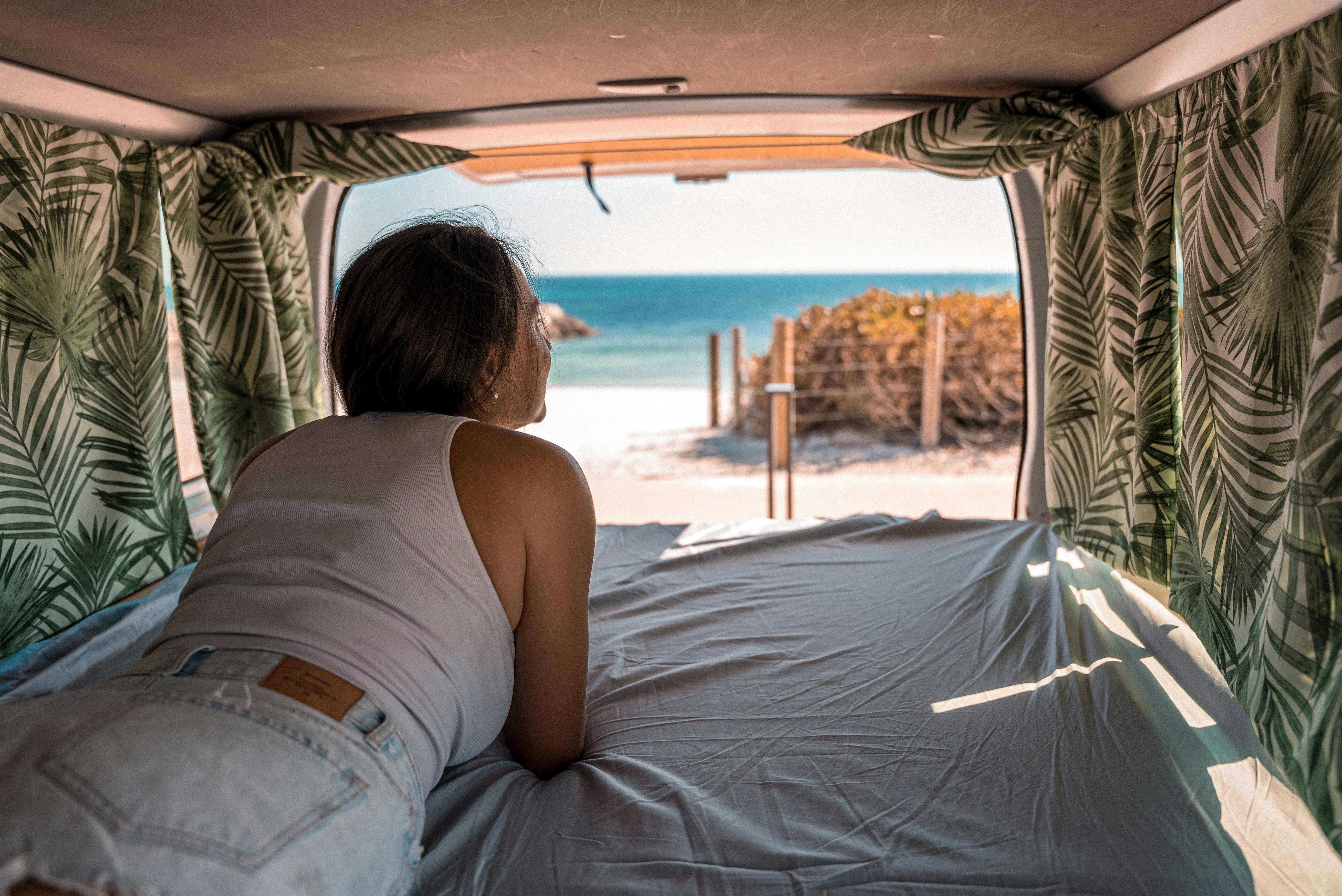 Girl looking at beach from inside van